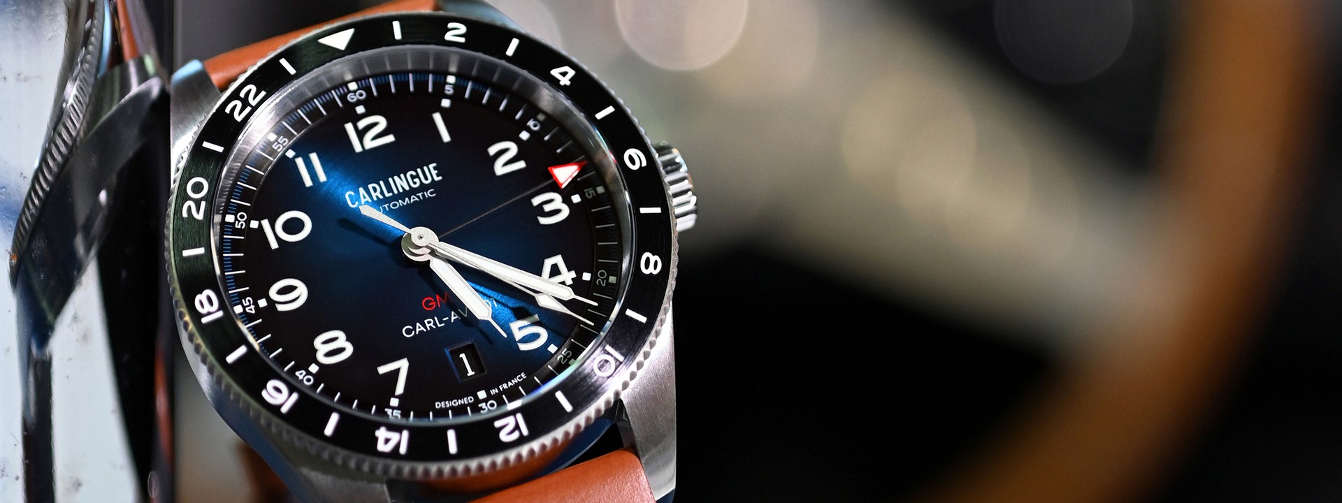 French automatic watch Carlingue Aviation 01, cognac leather strap, sunburst blue dial, stainless steel, on an American car